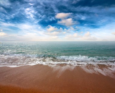 güneşli bir gökyüzü altında Akdeniz'in kumlu plaj