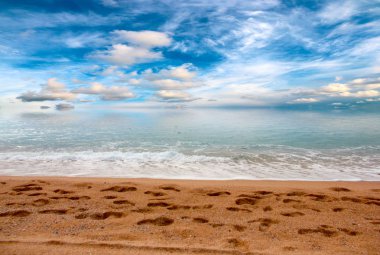 güneşli bir gökyüzü altında Akdeniz'in kumlu plaj