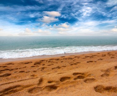 güneşli bir gökyüzü altında Akdeniz'in kumlu plaj