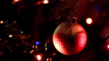 Noel ağacının dallarında şenlikli aydınlatma ve cam oyuncaklar