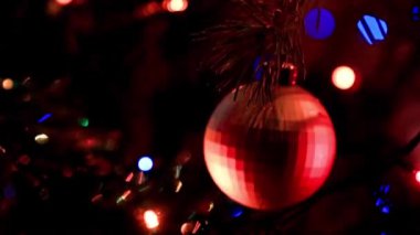 Noel ağacının dallarında şenlikli aydınlatma ve cam oyuncaklar