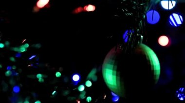 Noel ağacının dallarında şenlikli aydınlatma ve cam oyuncaklar