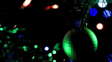 Noel ağacının dallarında şenlikli aydınlatma ve cam oyuncaklar