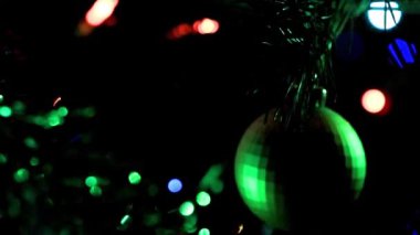 Noel ağacının dallarında şenlikli aydınlatma ve cam oyuncaklar