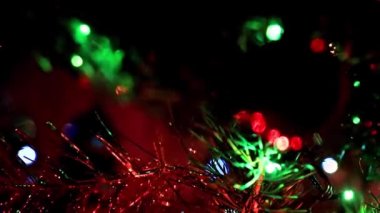 Noel ağacının dallarında şenlikli aydınlatma ve cam oyuncaklar