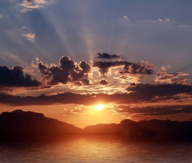 deniz üzerinde batan güneşin ışınları