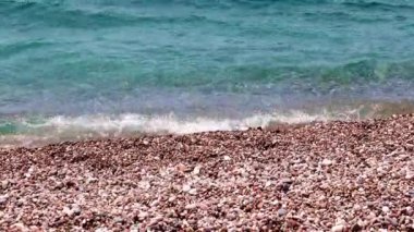 Akdeniz'in berrak su dalgaları ve Türkiye'nin çakıl plajı