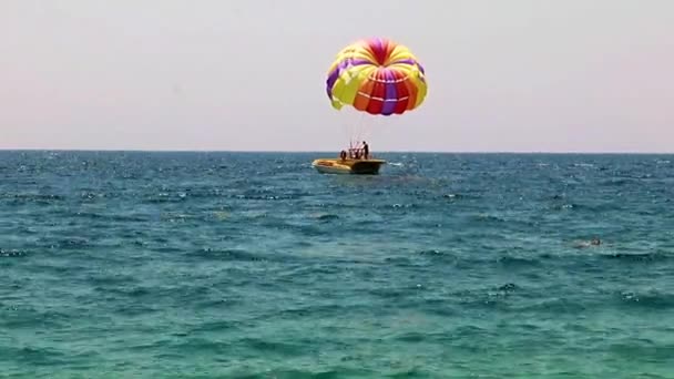 五颜六色的降落伞 在游客的海洋飞行 — 图库视频影像