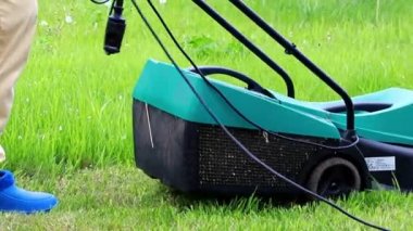 bir elektrikli çim biçme makinesi ile yeşil çim biçme