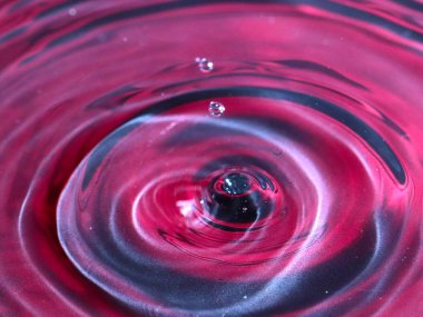 bir damla su, çok renkli bir sıvının yüzeyine düşer