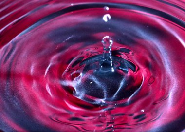 bir damla su, çok renkli bir sıvının yüzeyine düşer