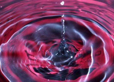 bir damla su, çok renkli bir sıvının yüzeyine düşer