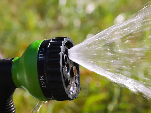 watering hose with a spray nozzle for moistening the lawn