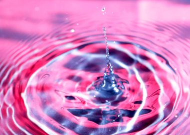 kırmızı sıvının yüzeyine bir damla su düşer