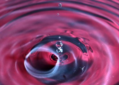 kırmızı sıvının yüzeyine bir damla su düşer