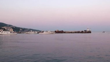 akşam liman feneri ve yelkenli gemiler