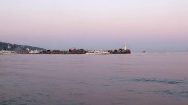 akşam liman feneri ve yelkenli gemiler