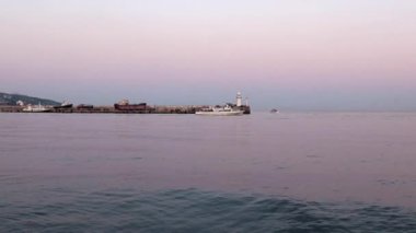 akşam liman feneri ve yelkenli gemiler