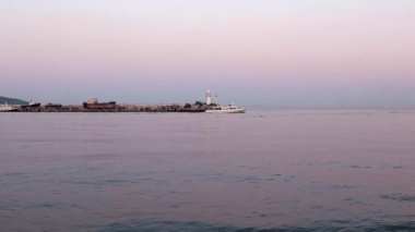 akşam liman feneri ve yelkenli gemiler