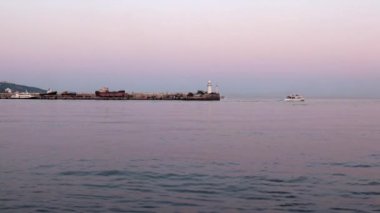 akşam liman feneri ve yelkenli gemiler