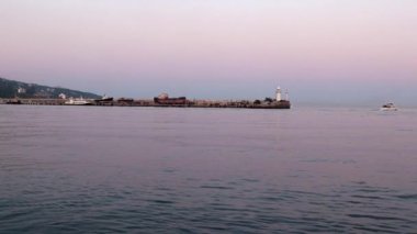 akşam liman feneri ve yelkenli gemiler