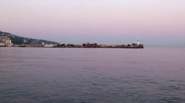 akşam liman feneri ve yelkenli gemiler