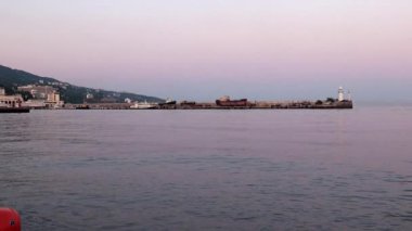 akşam liman feneri ve yelkenli gemiler