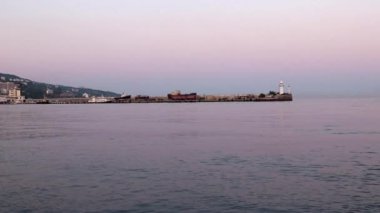 akşam liman feneri ve yelkenli gemiler