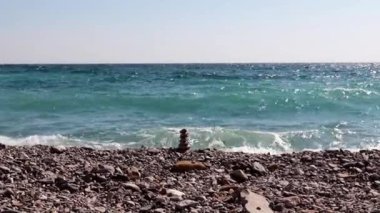 sahilde taş piramit ve deniz dalgaları