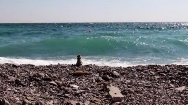 sahilde taş piramit ve deniz dalgaları