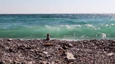 sahilde taş piramit ve deniz dalgaları