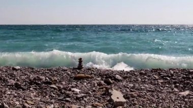 sahilde taş piramit ve deniz dalgaları