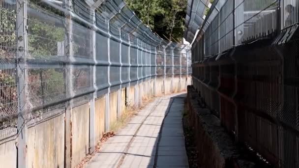 刑務所の歩行者通路の金属製のフェンス — ストック動画