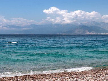 bir yaz bulutlu gökyüzü altında güneşli deniz plajı