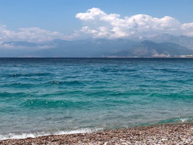 bir yaz bulutlu gökyüzü altında güneşli deniz plajı