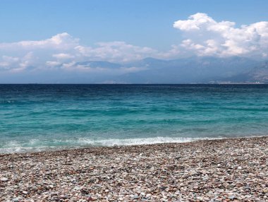 bir yaz bulutlu gökyüzü altında güneşli deniz plajı