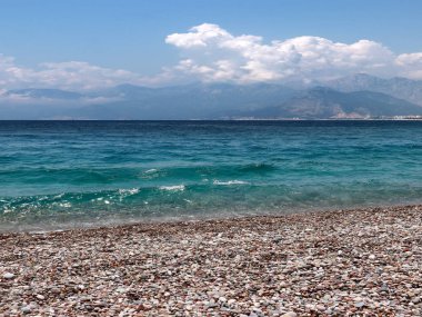 bir yaz bulutlu gökyüzü altında güneşli deniz plajı