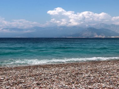 bir yaz bulutlu gökyüzü altında güneşli deniz plajı