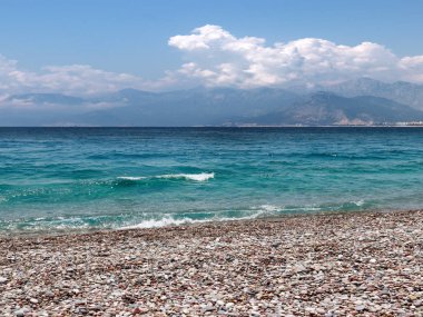 bir yaz bulutlu gökyüzü altında güneşli deniz plajı