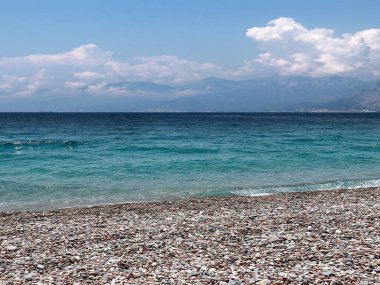 bir yaz bulutlu gökyüzü altında güneşli deniz plajı