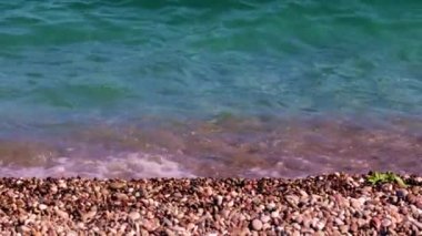 Deniz sörfü ve çakıl taşı plajının berrak suları