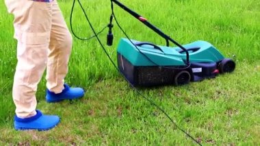 Çim biçme makinesiyle çimlerin çimlerini biçiyorum.