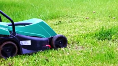 Çim biçme makinesiyle çimlerin çimlerini biçiyorum.