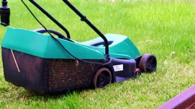 Çim biçme makinesiyle çimlerin çimlerini biçiyorum.