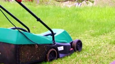 Çim biçme makinesiyle çimlerin çimlerini biçiyorum.