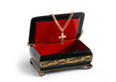 Süslü bir kutuda altın haç, zarif mücevherler.