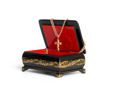 Süslü bir kutuda altın haç, zarif mücevherler.