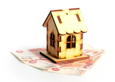 Bir yığın Rus rublesinin üzerindeki ahşap ev ipotek kredisi riskinin sembolü.