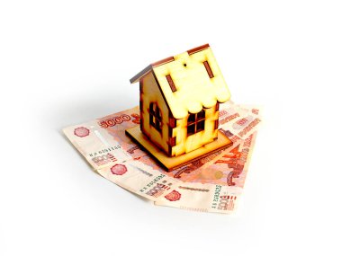 Bir yığın Rus rublesinin üzerindeki ahşap ev ipotek kredisi riskinin sembolü.