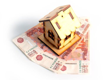 Bir yığın Rus rublesinin üzerindeki ahşap ev ipotek kredisi riskinin sembolü.